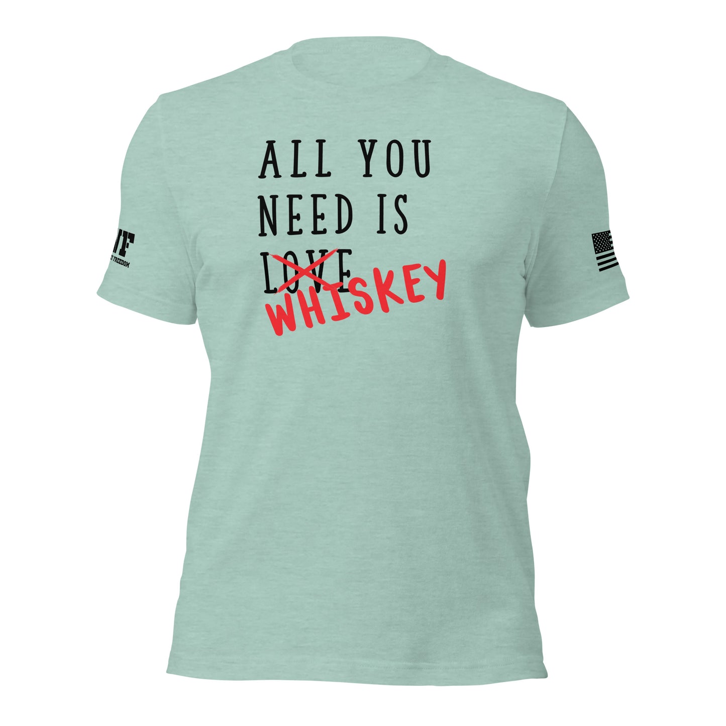 Rugged mint green t-shirt featuring bold, distressed text that says "All You Need Is Love" — the word "Love" is crossed out with a rough red strike-through, and the word "whiskey" is scrawled over it in a bold, handwritten style. The design blends humor and grit with a rebellious, rugged vibe.